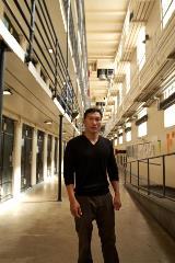 A picture of Eddie Zheng standing in front of jail cells